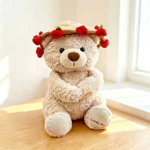 Detailed view of a beige plush bear wearing a rose-decorated hat on a wooden desk.