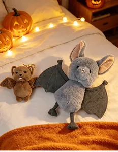 Peluche chauve-souris mignonne et porte-clés sur lit avec citrouilles
