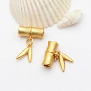 Detailaufnahme eines matten Gold-Bambusanhängers mit feinen, eleganten Blattanhängern