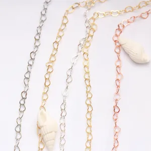 Détail de chaînes de bijoux cœur plaquées or 14K avec des pendentifs en coquille.