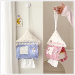 Detail showing house-shaped fabric tissue holders in blue and red gingham with lace trim.