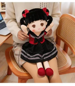 Close-up of a cute plush doll in a red and black school uniform, held on a lap.
