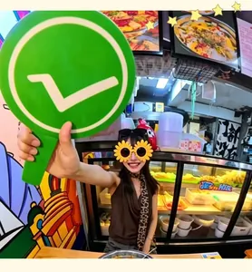 Handheld green sign with white tick mark for food reviews and travel photos