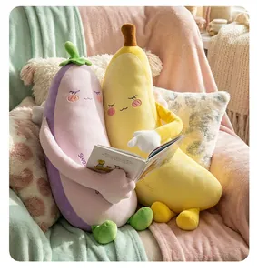 Nahaufnahme von süßen Bananen- und Auberginen-Plüschkissen, die sich auf dem Sofa umarmen