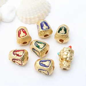 Close-up of antique gold Thai Buddha beads with colorful enamel for DIY jewelry