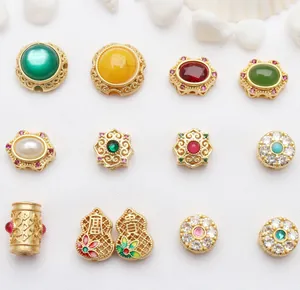 Dettaglio di perline distanziatrici in oro antico stile Nepal con gemme colorate per DIY