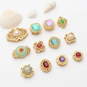 Macro view of assorted gold-plated filigree beads featuring colorful gemstone and pearl inlays