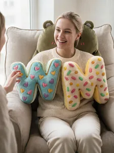Primer plano de cojines de peluche con letras W y M temáticas de donut