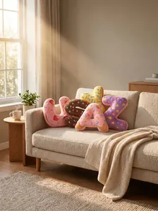 Cojines de peluche con letras de donut en un acogedor sofá crema en una habitación
