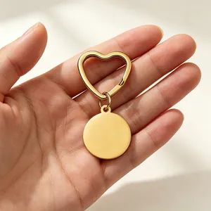 Close-up of a gold stainless steel heart-shaped keychain with a round blank pendant.