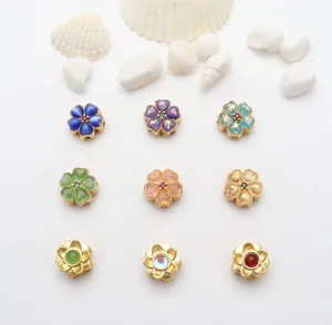 Detailansicht farbenfroher Blumenscharms für DIY-Schmuckherstellung auf weißem Grund.