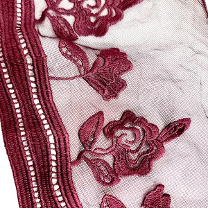 Close-up view of intricate burgundy floral embroidery patterns on delicate mesh lace trim.