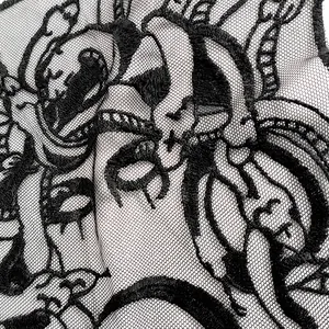 Detaillierte Makroaufnahme von schwarzer Medusa-Stickerei auf Mesh-Gewebe im Gothic-Stil