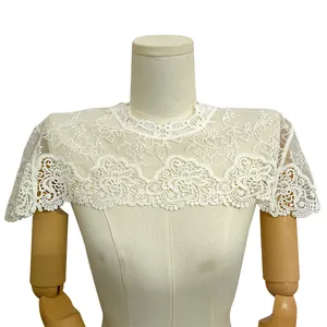 Détail du châle en dentelle brodée de soie de lait blanche avec motif ajouré floral