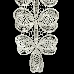 Close-up of white polyester lace with embroidered butterfly and hollowed floral pattern