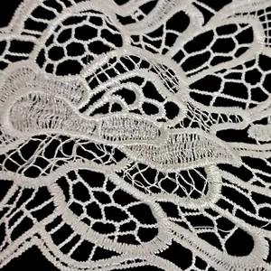 Makroansicht der komplizierten Details des weißen Stickspitzenmusters aus Polyester