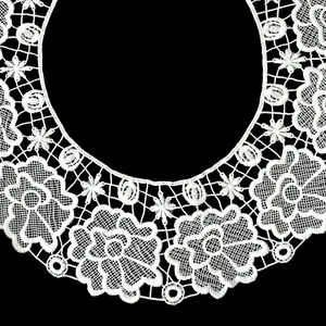Macro view of intricate white milk silk embroidered lace floral pattern on black background