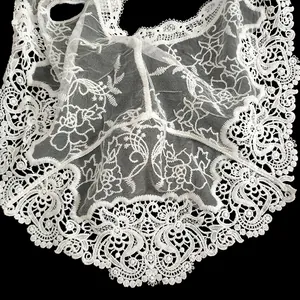 Détail de la dentelle brodée en soie de lait blanche avec des motifs floraux évidés