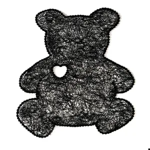 Close-up of black lace bear embroidery patch with delicate heart-shaped cutout detail.