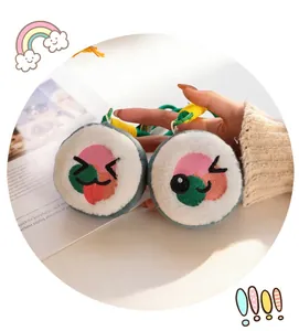 Close-up detail of cute plush sushi roll seaweed rice charms with embroidered faces