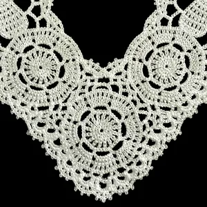 Detailed macro view of white hollow floral lace embroidery on a polyester collar