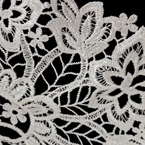 Makroansicht der komplizierten Textur weißer floraler Polyester-Spitzenstickerei für Mode