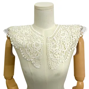 Détail du faux col en dentelle brodée de soie de lait blanche avec motif floral évidé