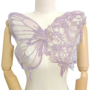 Detailansicht eines lila Schmetterling-Blumen-Spitzenstickerei-Patches auf einer Schaufensterpuppe