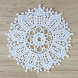 Close-up of white vintage water-soluble lace coaster with hollow floral embroidery