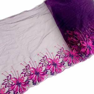 Detailed view of purple mesh fabric with intricate pink floral embroidery edge.