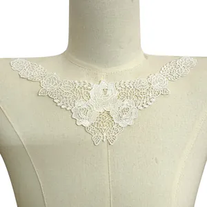 Macro detail of delicate white rose lace embroidery collar on a fabric mannequin torso
