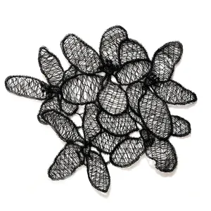 Detailed macro view of delicate black fish silk embroidery lace hollowed flower patch