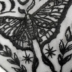 Detaillierte Nahaufnahme einer exquisiten schwarzen Schmetterlingsstickerei auf Netz