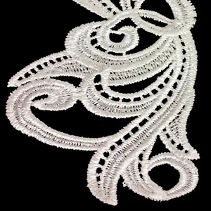 Macro detail of white water-soluble lace embroidery with intricate hollow-out floral patterns