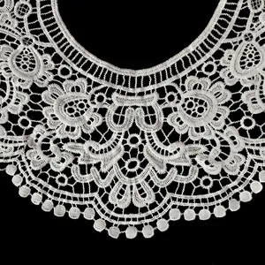 Vue détaillée du faux col en dentelle de soie de lait blanche brodée avec élégance.