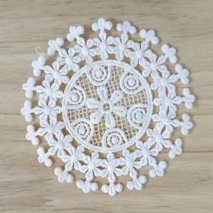 Close-up detail of a white vintage water-soluble lace patch with intricate embroidery