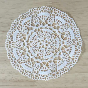 Detailed view of white vintage water-soluble lace coaster with intricate embroidery