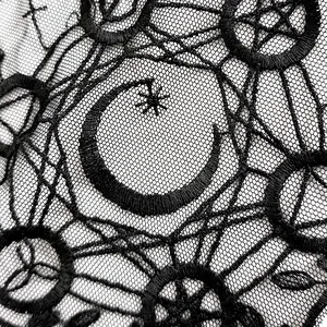 Detailansicht aus schwarzer bestickter Spitze mit gotischen Mond- und Sternmotiven