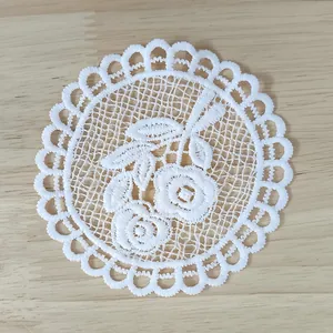 Top view detail of white vintage water-soluble lace coaster with floral embroidery