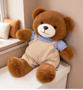 Close-up of a cute plush teddy bear wearing blue shirt and beige corduroy overalls