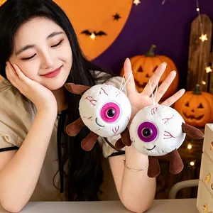 Halloween gruselige Augapfel Plüsch Anhänger Spielzeug von einem lächelnden Modell gehalten