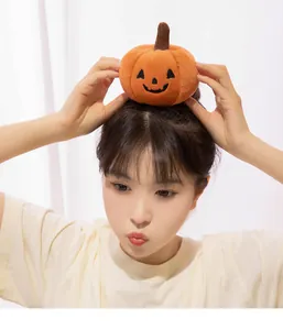 Close-up of a model wearing a quirky Halloween plush pumpkin doll on her head.