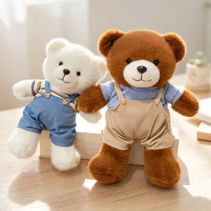 Detailed view of two cute plush teddy bears wearing stylish overalls on a wooden table