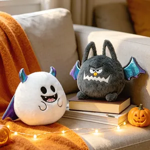 Δύο χαριτωμένα λούτρινα Halloween: λευκό φάντασμα και γκρι νυχτερίδα στον καναπέ