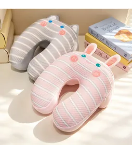 Detalle de almohadas de viaje en forma de U con rayas y motivos de animales suaves