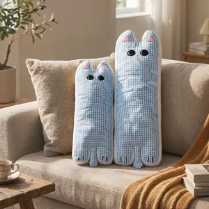 Adorables traversins longs en forme de chat en seersucker vichy bleu sur un canapé beige
