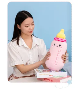 Close-up of a cute baby bottle plush pillow held by a model showing soft fabric and scale detail