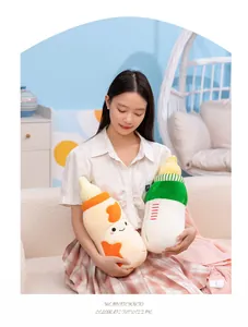 Asian woman holding two cute baby bottle shaped plush pillows in a cozy room setting