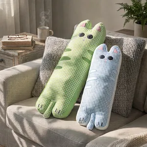 Paire de longs coussins chat à carreaux verts et bleus sur un canapé très doux
