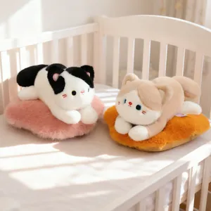 Cute plush cat dolls in cow and siamese styles lying on soft fluffy pillows in a crib